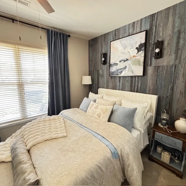 Soft neutral bedroom with textured accent wall and layered bedding